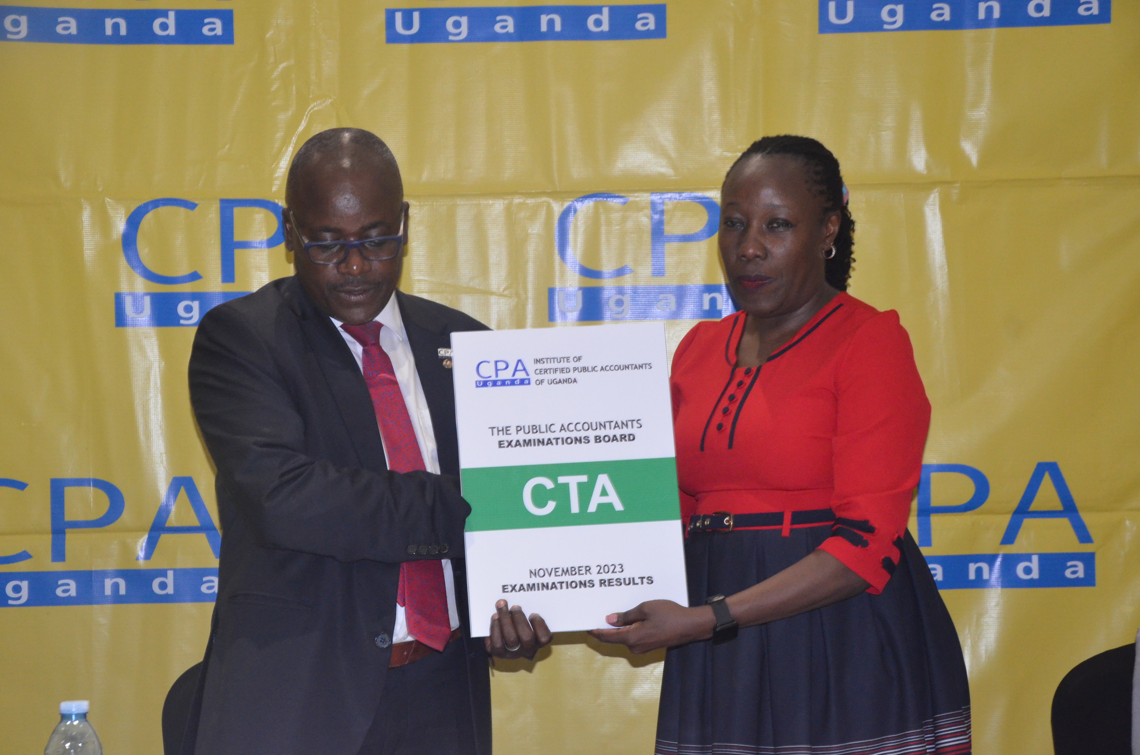 CPA Pro Laura Orobia, Chairperson PAEB  hands over the CTA November Examinations 2023 results to Ronald Mutumba, Vice President of ICPAU.