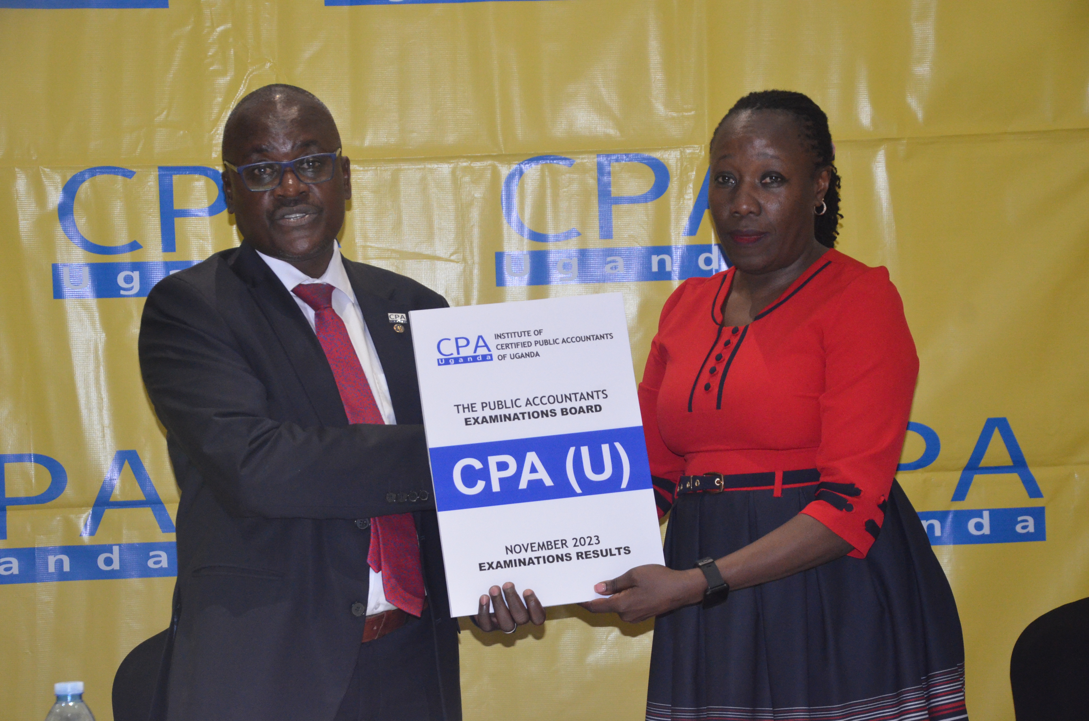 CPA Pro Laura Orobia, Chairperson PAEB  hands over the CPA (U) November Examinations 2023 results to Ronald Mutumba, Vice President of ICPAU