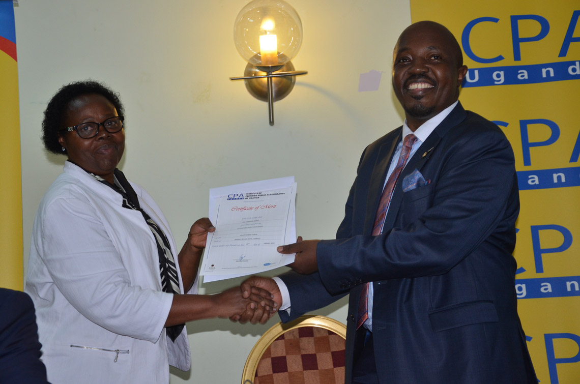 CPA Edna Rugumayo handing a certificate to CPA Frederick Kibbedi (ICPAU President), in honour of his presentation.