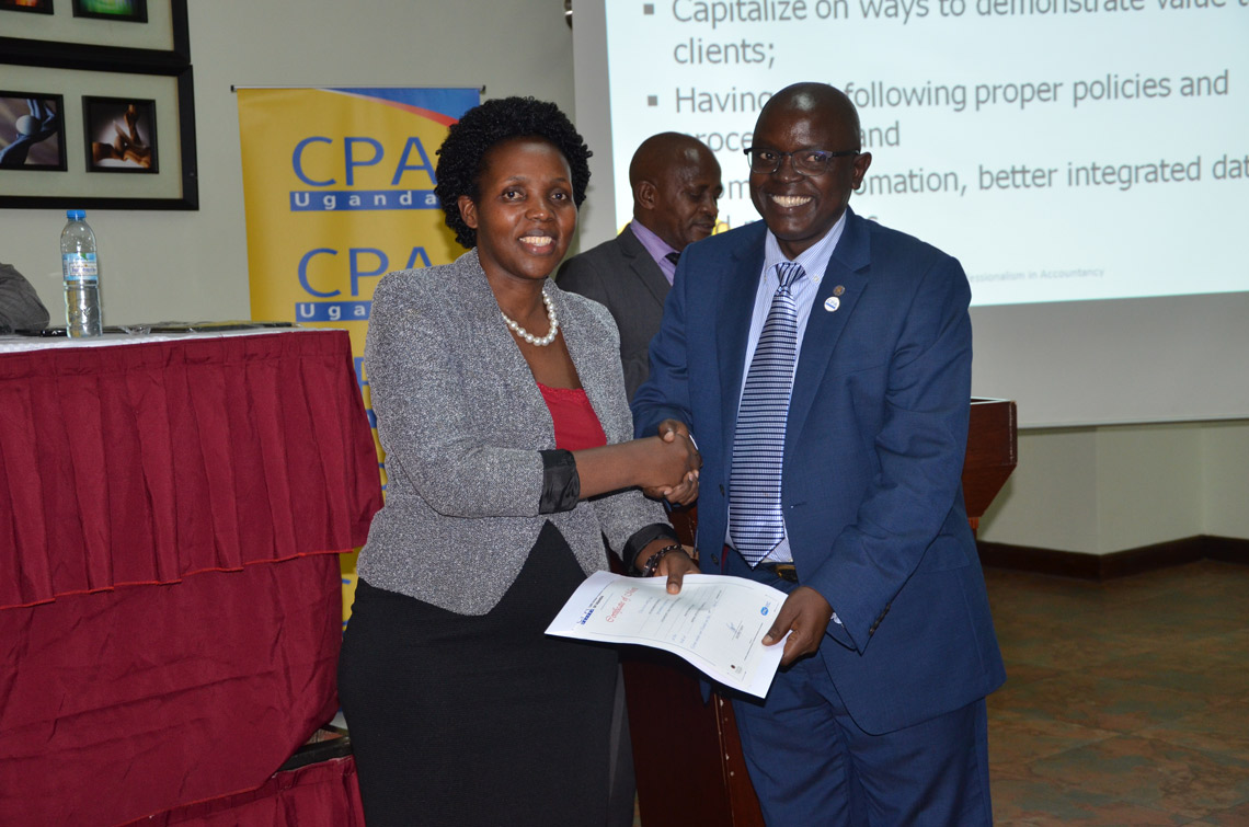 CPA Kelemensio Busingye (L) received a certificiate in honour of her presentation. CPA Constante Mayende (R) handed the certificate