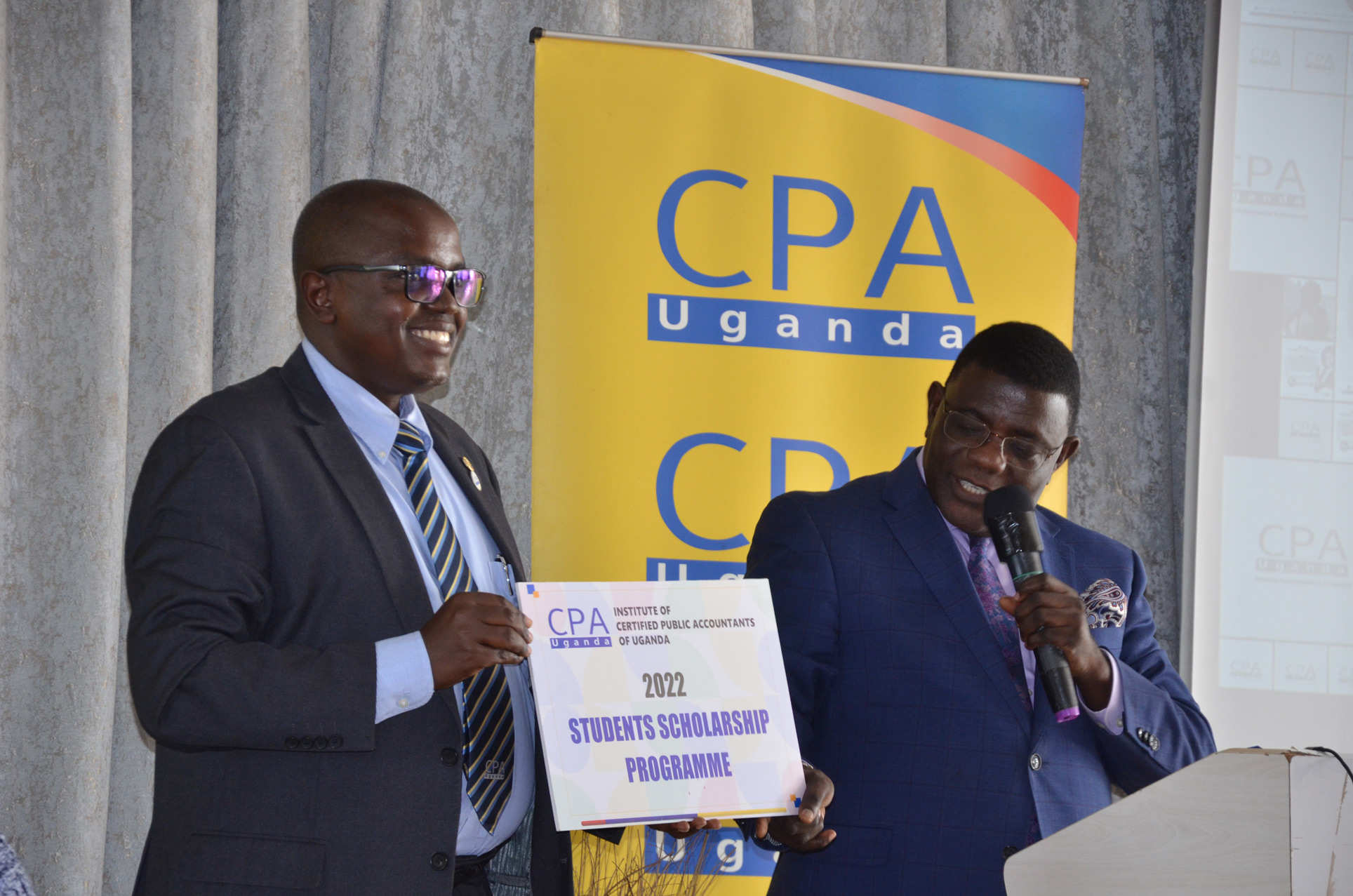 ICPAU President, CPA Constant Othieno Mayende (L) and Prof. Twaha Kaawaase (the Chief Guest) launch the 2022 Scholarships
