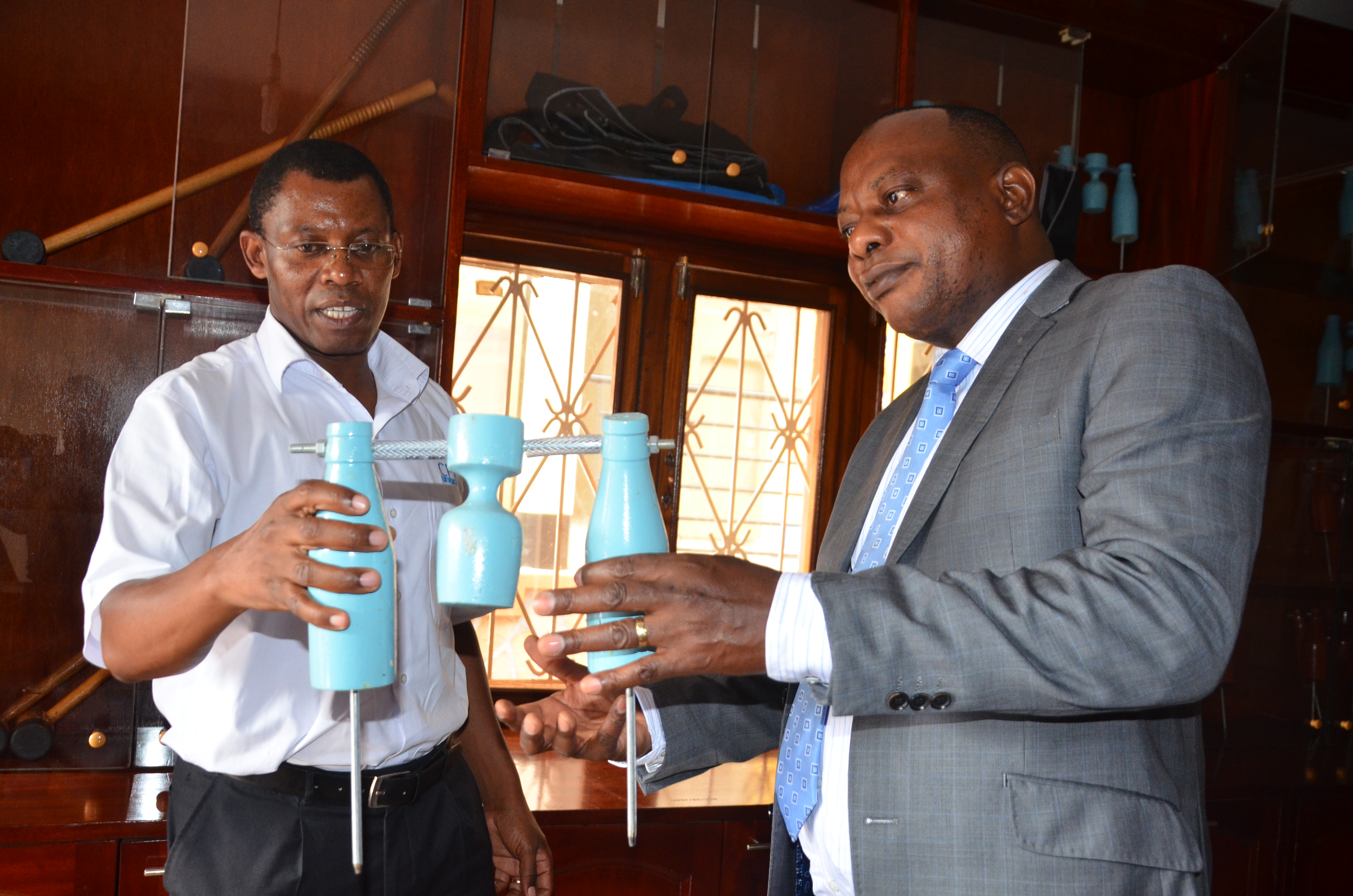 The President of the Woodball Federation, Paul Mark Kayongo showing the ICPAU CEO some of the equipment used to play the Wodball Sport